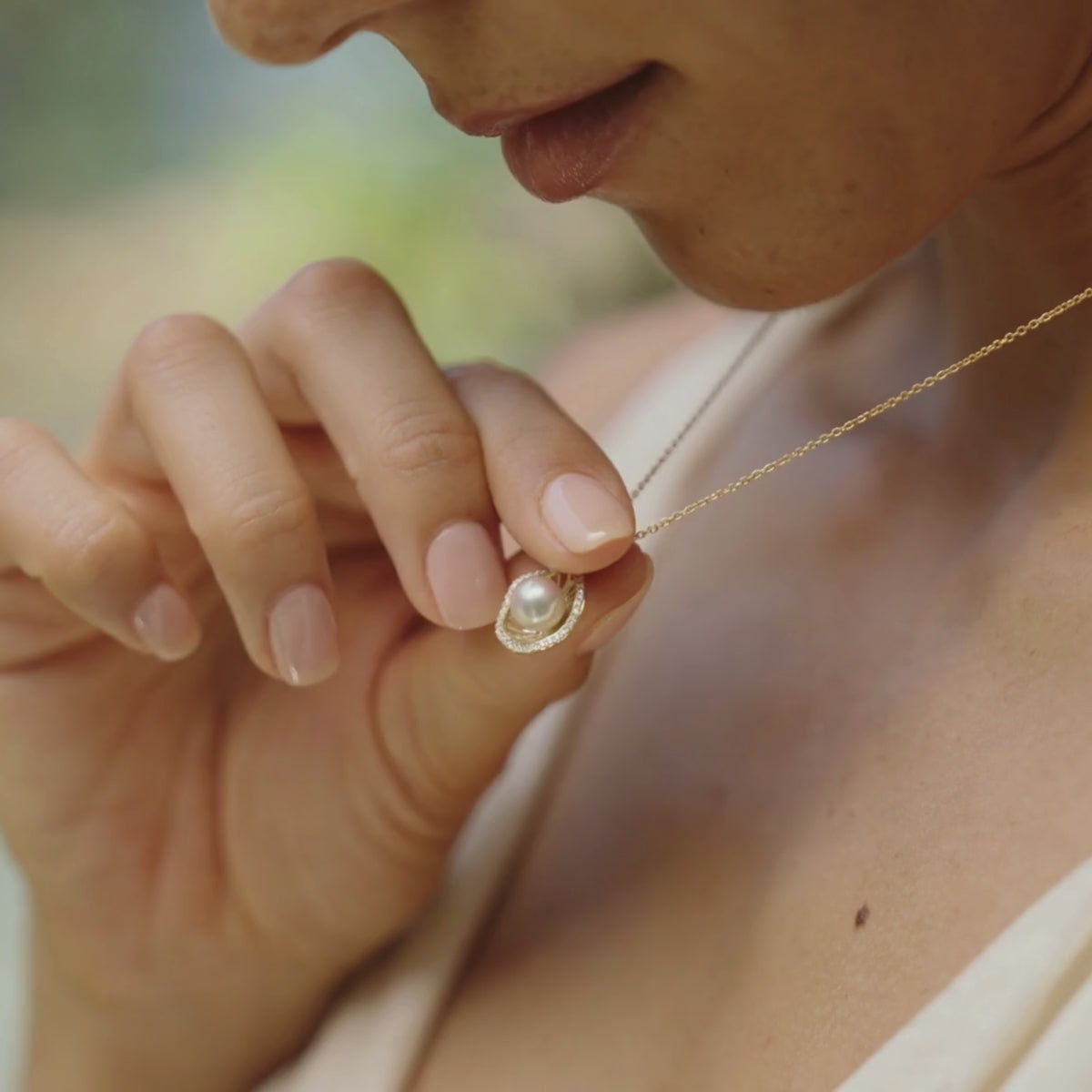 A woman wears her stunning Mangrove Lily Diamond Pearl Pendant that features our Australian Akoya pearl that shines with its innate colour and lustre, grown at our very own Broken Bay Pearl Farm in NSW.