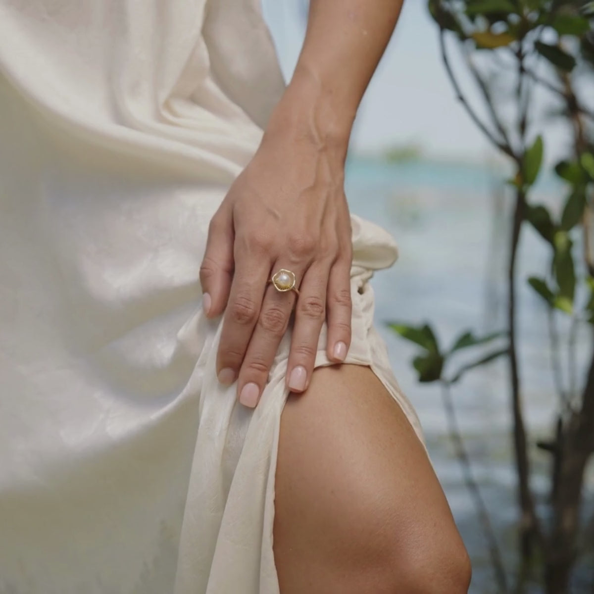 A woman wears her stunning Mangrove Lily Pearl Ring that features our stunning Australian Akoya pearls grown at our Broken Bay Pearl Farm in NSW while she stands amongst the mangroves. 