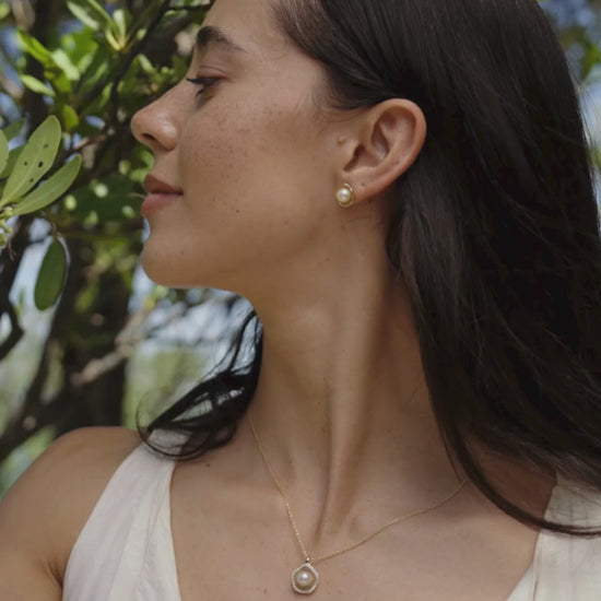 A woman wears her stunning Mangrove Lily Pearl Stud Earrings that feature our Australian Akoya pearls set in a stunning filigree design.