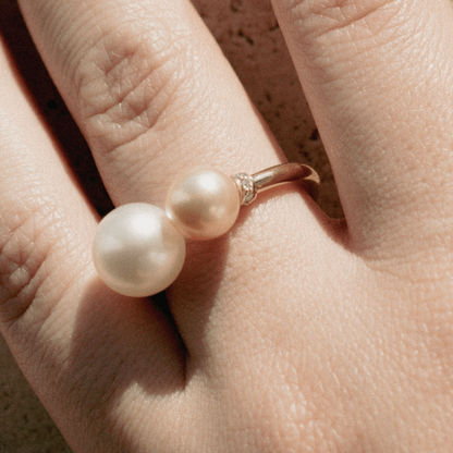 A woman wears her Provenance Open Diamond Rondel Pearl Ring features a Cygnet Bay (WA) grown Australian South Sea pearl and two Broken Bay (NSW) grown Australian Akoya pearls set on a gold band, with two sparkling diamond rondels.